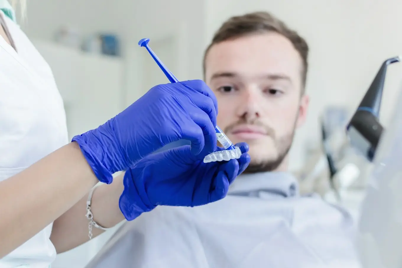 mężczyzna wybiela zęby u stomatologa
